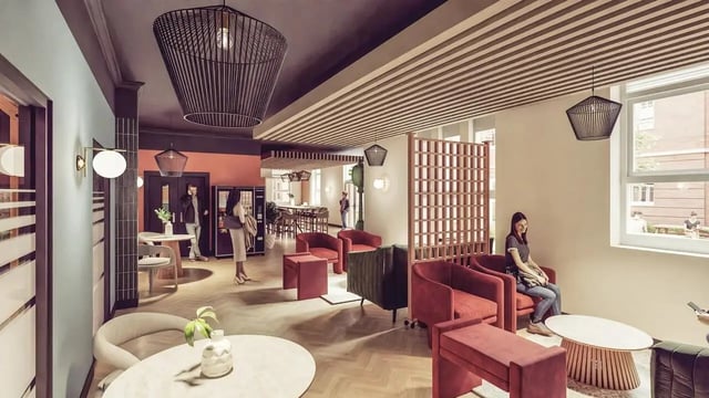 Modern lounge with red chairs and wooden screen communal area at St Chads Student Village in Birmingham Student Accommodation