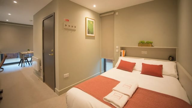 Bed with orange throw and red pillows bedroom at Beechenhurst House in Birmingham Student Accommodation