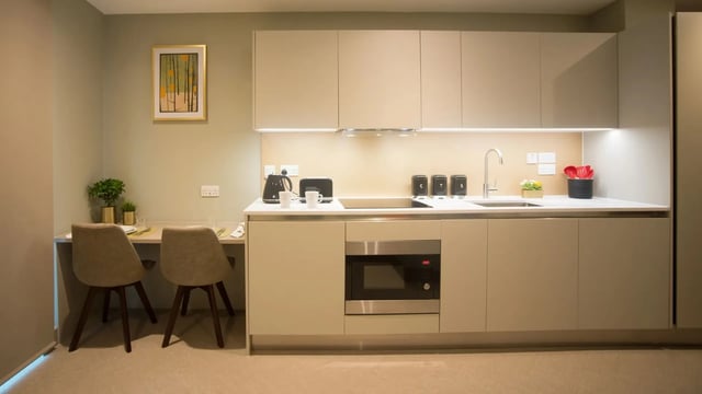 Two chairs small table kitchen counter microwave kitchen at Beechenhurst House in Birmingham Student Accommodation
