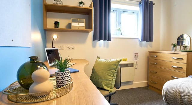 Desk lamp laptop green cushion dresser bedroom at Barker House in Newcastle Upon Tyne Student Accommodation
