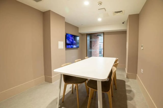 White table and chairs with wall mounted television common room at Yugo Crown Place in Birmingham Student Accommodation