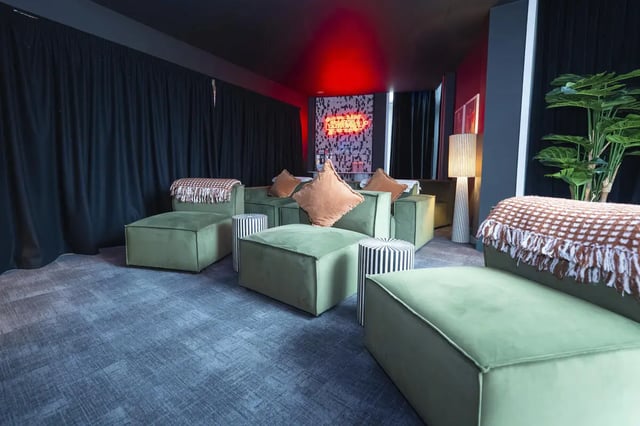 Green sofas with cushions and throws cinema room at Aparto Arbury Court in Kingston Upon Thames Student Accommodation