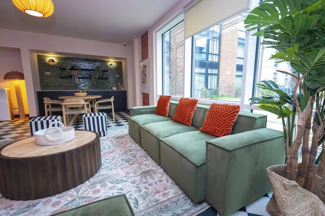 Green sofa orange cushions coffee table living room at Aparto Arbury Court in Kingston Upon Thames Student Accommodation