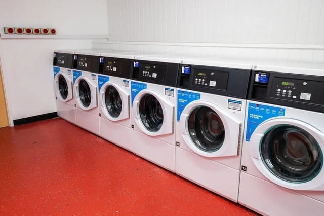 Multiple washing machines on red floor laundry room at Marybone Student Village 1 in Liverpool Student Accommodation
