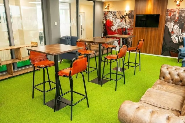 Bar stools and tables on green carpet living room at Marybone Student Village 1 in Liverpool Student Accommodation