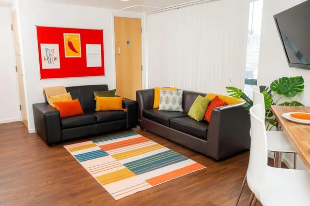 Two black couches colorful pillows striped rug living room at Marybone Student Village 2 in Liverpool Student Accommodation