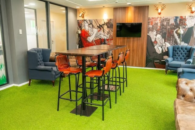 High bar tables with orange chairs modern seating area at Marybone Student Village 2 in Liverpool Student Accommodation