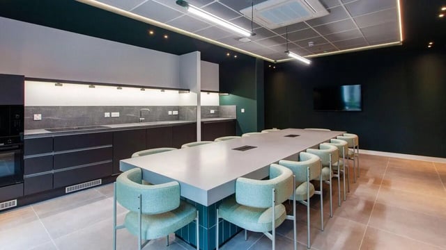 Modern kitchen with long table and chairs communal area at Sheares Hall in Newcastle Upon Tyne Student Accommodation
