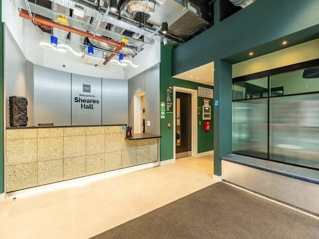 Reception desk with welcome sign and seating area exterior at Sheares Hall in Newcastle Upon Tyne Student Accommodation