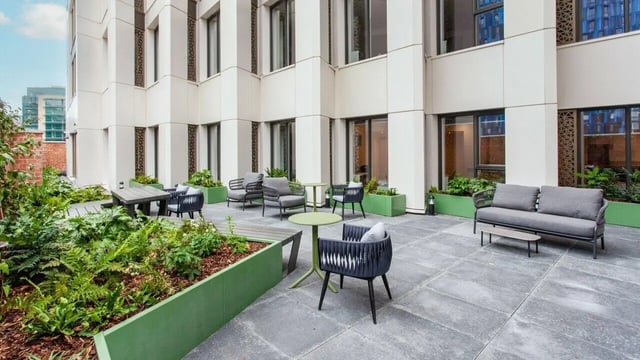 Modern seating area with garden patio and building exterior at Sheares Hall in Newcastle Upon Tyne Student Accommodation