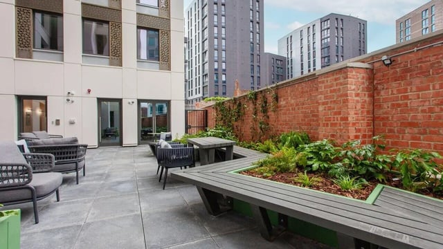 Outdoor seating with benches tables and plants exterior at Sheares Hall in Newcastle Upon Tyne Student Accommodation