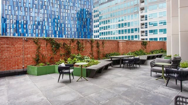 Outdoor seating area with tables and benches exterior at Sheares Hall in Newcastle Upon Tyne Student Accommodation