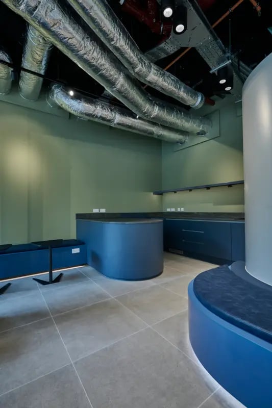 Blue reception desk with seating and ducts Kitchen at Sheares Hall in Newcastle Upon Tyne Student Accommodation