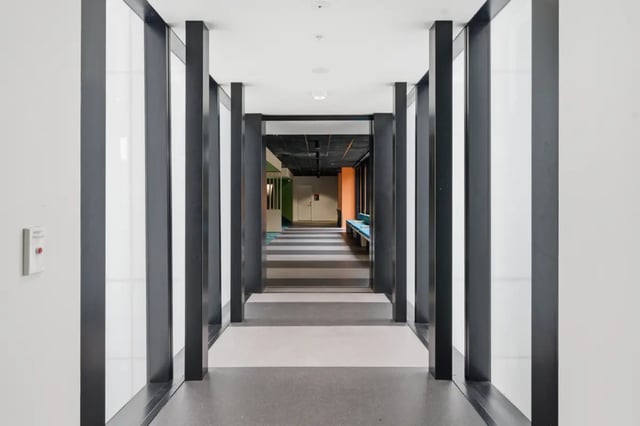 Modern hallway with striped floor and blue benches corridor at Mayoral Drive Student Accommodation in Auckland Student Accommodation