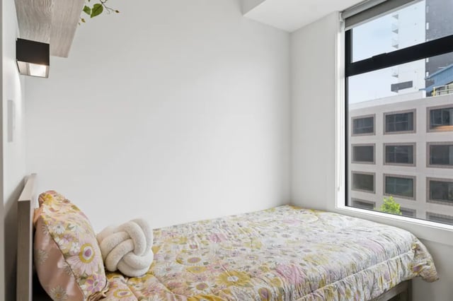 Bed with floral quilt and decorative pillows Bedroom at Mayoral Drive Student Accommodation in Auckland Student Accommodation