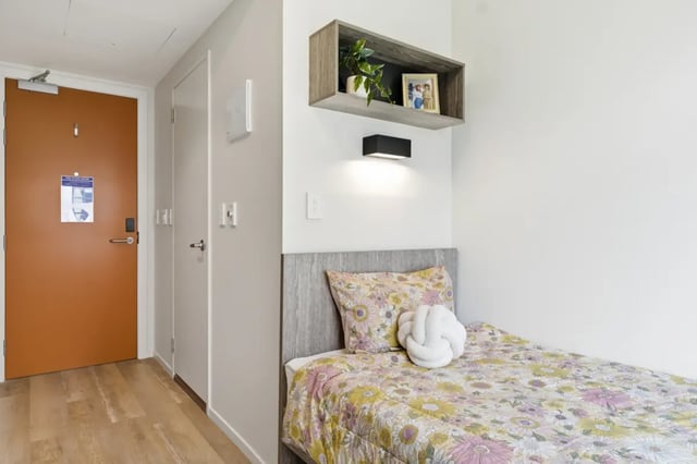 Bed with floral bedding and knot pillow bedroom at Mayoral Drive Student Accommodation in Auckland Student Accommodation