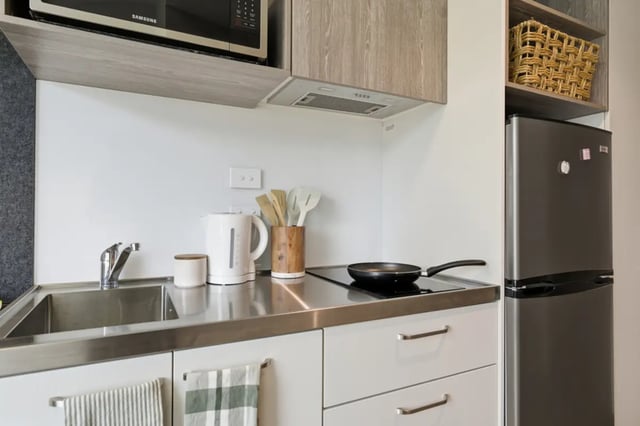 Sink kettle utensils frying pan and fridge kitchen at Mayoral Drive Student Accommodation in Auckland Student Accommodation
