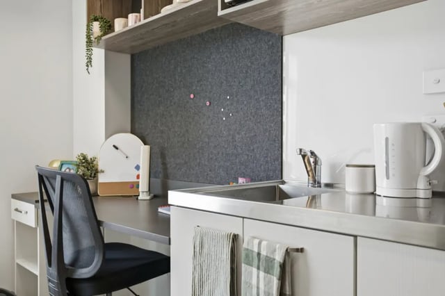 Desk chair whiteboard kettle sink kitchenette at Mayoral Drive Student Accommodation in Auckland Student Accommodation