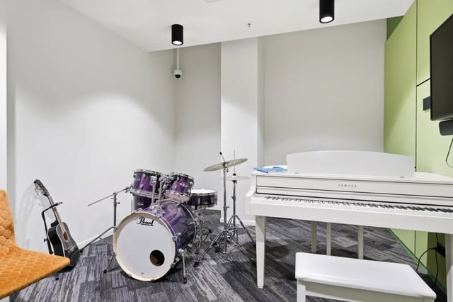 Drum kit piano guitar orange chair playing area at Mayoral Drive Student Accommodation in Auckland Student Accommodation