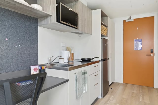 Desk microwave sink fridge and door kitchen at Mayoral Drive Student Accommodation in Auckland Student Accommodation