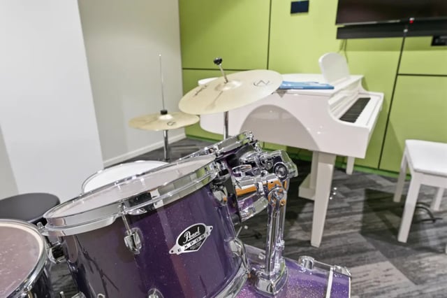 Drum set white piano and white stool entertainment area at Mayoral Drive Student Accommodation in Auckland Student Accommodation