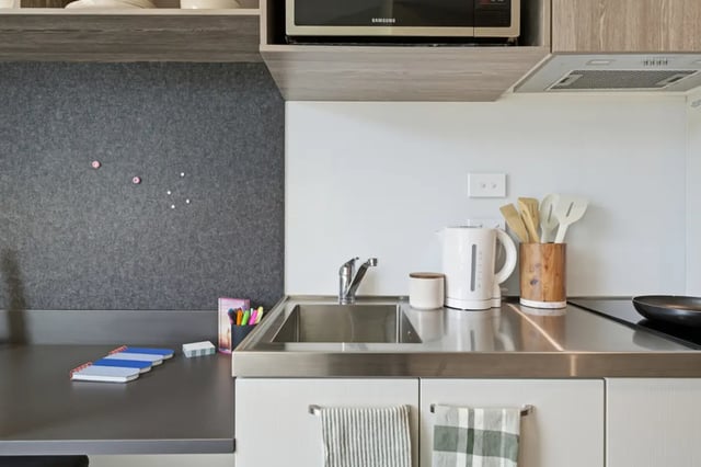 Sink kettle utensils notebooks whiteboard kitchen at Mayoral Drive Student Accommodation in Auckland Student Accommodation