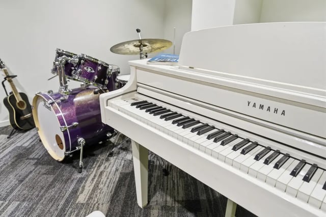 White grand piano drum set guitar common area at Mayoral Drive Student Accommodation in Auckland Student Accommodation