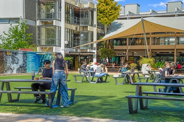 Students sit at picnic tables on green lawn exterior at Mayoral Drive Student Accommodation in Auckland Student Accommodation