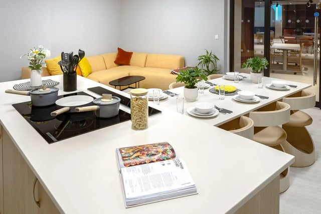 Kitchen island with pots stove and dining table kitchen at True Nottingham in Nottingham Student Accommodation