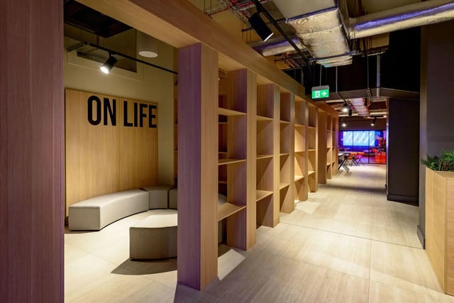 Seating area with shelves and sign communal space at True Nottingham in Nottingham Student Accommodation