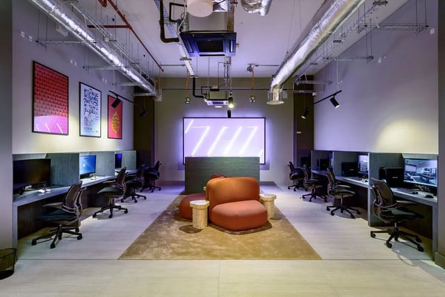 Computers desks and chairs with a large screen study area at True Nottingham in Nottingham Student Accommodation