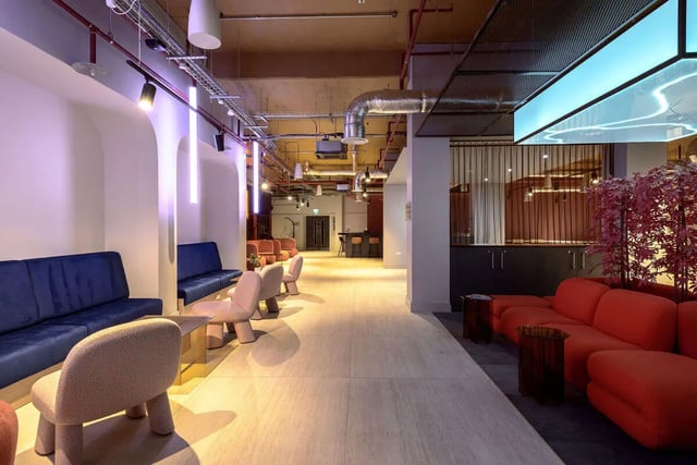 Modern communal space with blue and red sofas living area at True Nottingham in Nottingham Student Accommodation