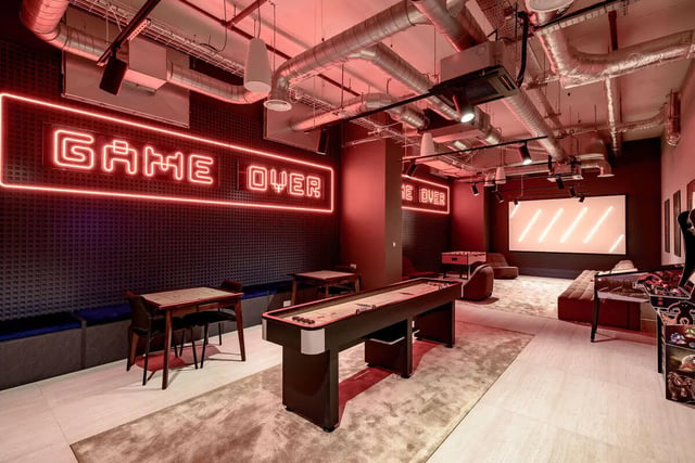 Shuffleboard table neon signs lounge gaming area at True Nottingham in Nottingham Student Accommodation