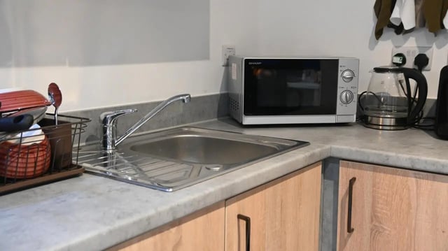 Sink microwave kettle dishes and cutlery kitchen at Hill View Place in Exeter Student Accommodation