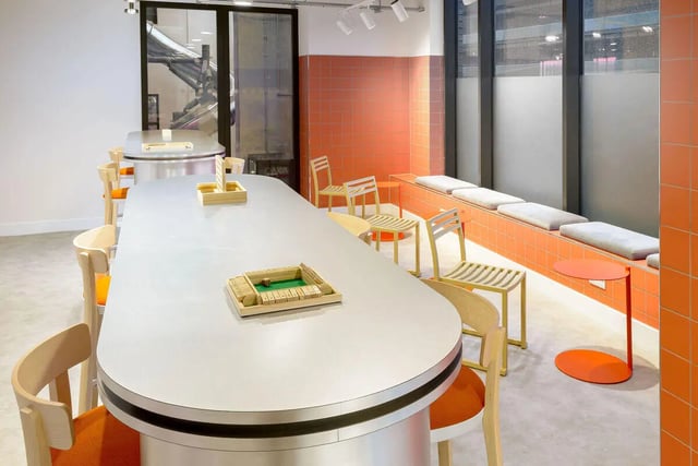 Long table with chairs and built-in bench seating communal area at True Sheffield in Sheffield Student Accommodation