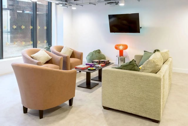 Sofa armchairs coffee table with games living room at True Sheffield in Sheffield Student Accommodation