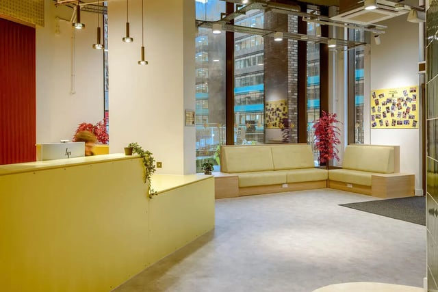 Yellow reception desk couches and plants common area at True Sheffield in Sheffield Student Accommodation