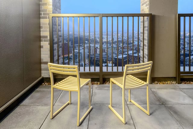 Two yellow chairs on balcony with city view balcony at True Sheffield in Sheffield Student Accommodation