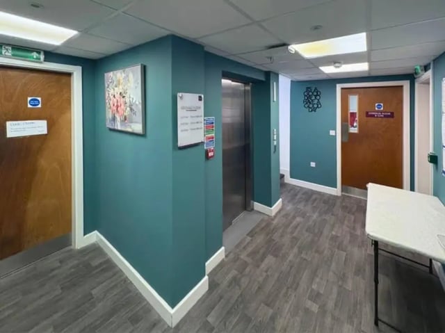 Hallway with elevator doors artwork and table hallway at The Cube Greenwich in London Student Accommodation