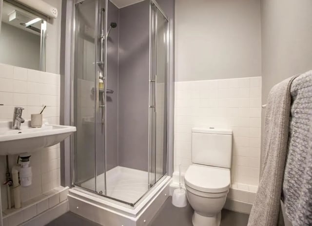 Sink shower toilet and towel bathroom at Halsmere Studios in London Student Accommodation