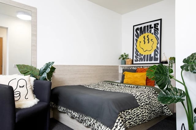 Bed pillows chair with abstract face pillow bedroom at The Bakery in Cardiff Student Accommodation