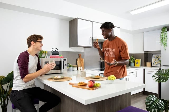 Two students talking food on kitchen counter kitchen at The Bakery in Cardiff Student Accommodation