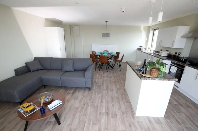 Sofa dining table kitchen island living room at LIV Student Belfast in Belfast Student Accommodation