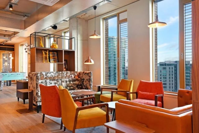 Colorful chairs sofas shelving with decor and foosball table living room at LIV Student Sheffield in Sheffield Student Accommodation