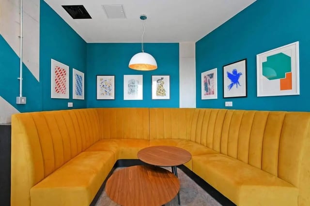 Yellow sectional sofa with two tables living room at LIV Student Sheffield in Sheffield Student Accommodation