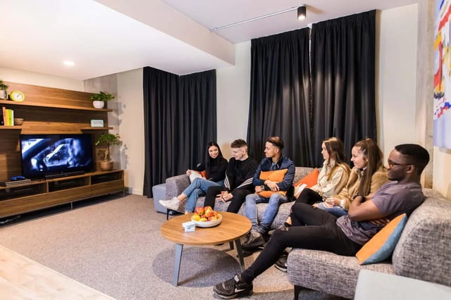 Students relaxing on sofa watching TV living room at LIV Student Sheffield in Sheffield Student Accommodation