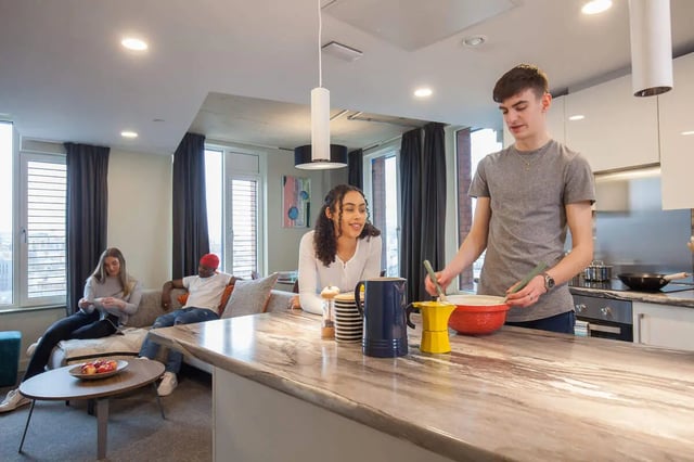 Students cooking at kitchen counter living room kitchen at LIV Student Sheffield in Sheffield Student Accommodation