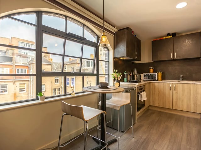 Round table with stools and kitchen counter kitchen at St Peter's Hall in Bournemouth Student Accommodation
