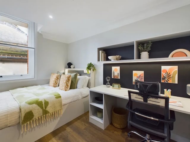 Bed with patterned throws and study desk Bedroom at 26 Great George Street in Leeds Student Accommodation
