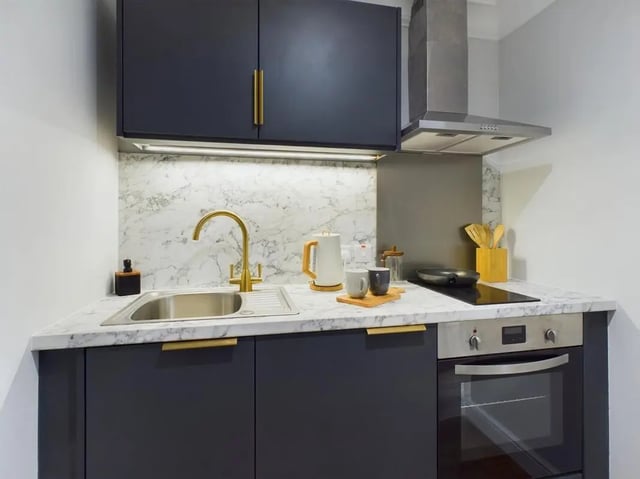 Modern dark cabinets marble backsplash sink and oven kitchen at 26 Great George Street in Leeds Student Accommodation